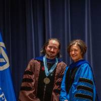 Provost Mili smiles for picture with faculty member